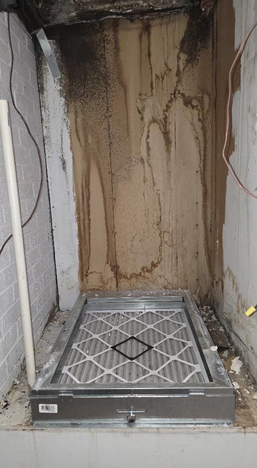 A severely water-stained and moldy wall with an HVAC filter unit, showing extensive water damage requiring restoration by ABS Restoration Services, Inc. in North Little Rock, AR