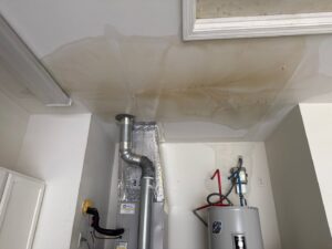 Visible water stains on a ceiling in a garage or utility room, indicating water damage, by PuroClean of Hilton Head in Bluffton, SC.