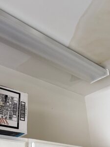 Water stains visible on a ceiling near a fluorescent light fixture, indicating water damage, by PuroClean of Hilton Head in Bluffton, SC.