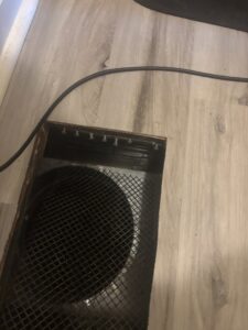 Close-up of a floor vent showing clear water stains and discoloration on the surrounding laminate flooring, indicating water damage, addressed by COIT Cleaning and Restoration in Indianapolis, IN.