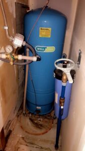 Water stains and discoloration on the floor around a water tank, indicating a past leak or water damage, addressed by Quality Remediation llc in Everett, WA.