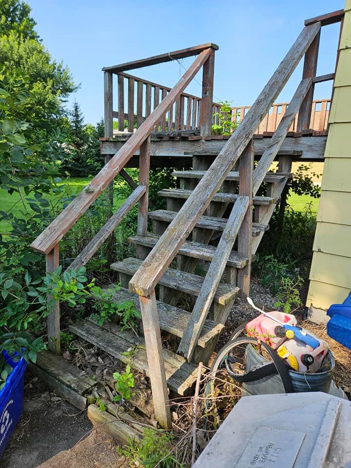An old, weathered wooden deck staircase showing signs of rot and water damage, ready for repair by Grand Rising Group in Mitchell, SD.