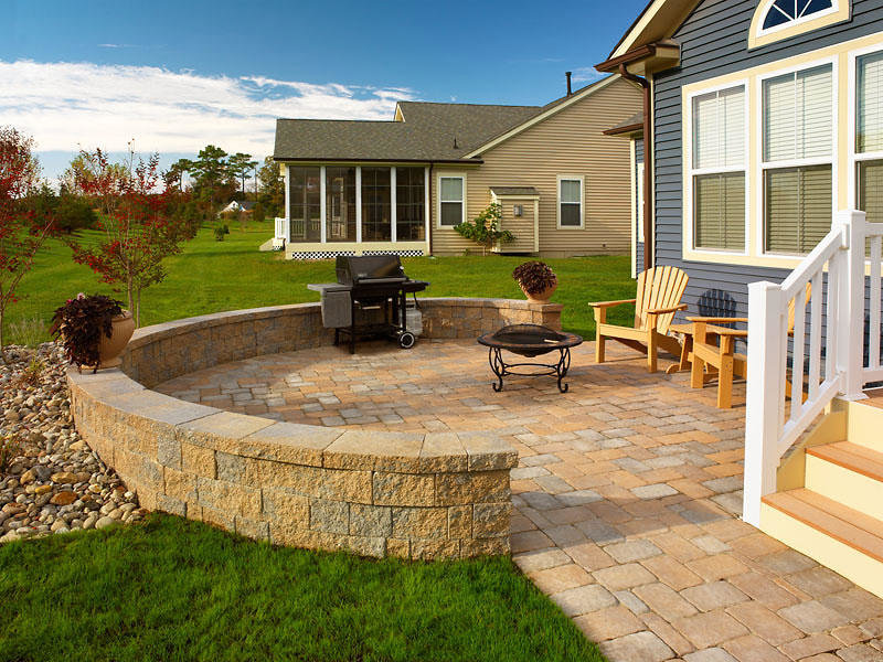 A well-kept green lawn complementing an outdoor living space with a patio and fire pit by Bailey's Lawn and Landscape in Smyrna, DE.