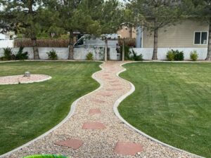 A well-maintained backyard lawn with a decorative gravel path by Lakeside Lawn Care in Sanford, NC.