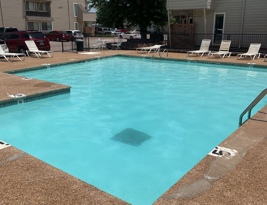A well-maintained community swimming pool with clear blue water, cleaned by AquaDocs in Dublin, OH.