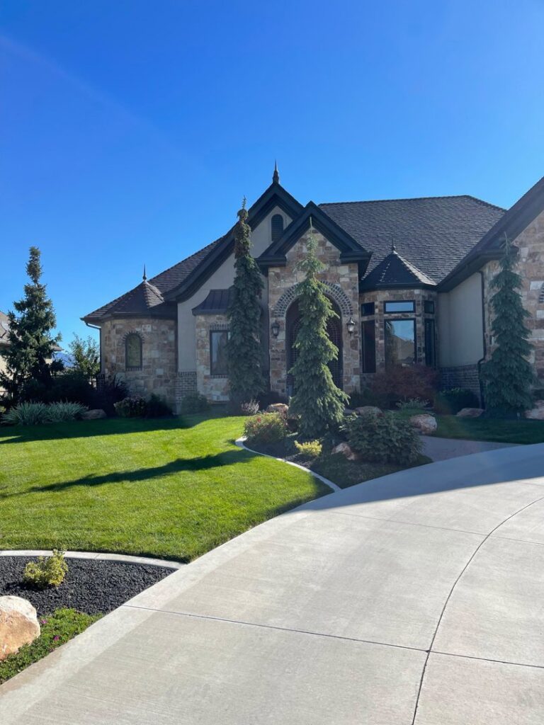 A beautifully well-maintained front lawn and landscaping at a home by M.D. Lawn Care & Landscaping in West Jordan, UT