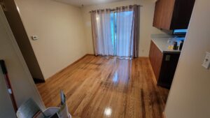 A kitchen and dining area with wet hardwood floors, indicating recent cleaning by Eyedeal Cleaning Services in Gresham, OR.