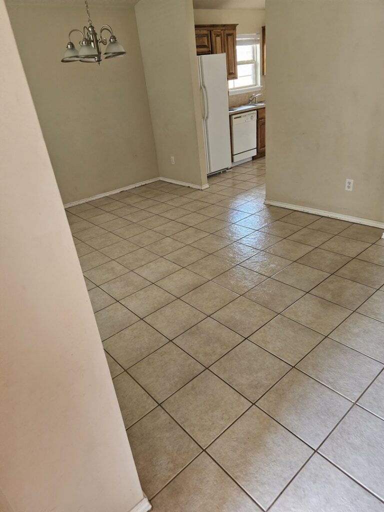 A wet and shiny tiled floor in a kitchen area, freshly cleaned by Clara's Cleaning LLC in Oklahoma City, OK.