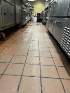A wet, tiled floor in a commercial kitchen after professional cleaning by Flawless Home & Business Cleaning LLC in Fargo, ND.