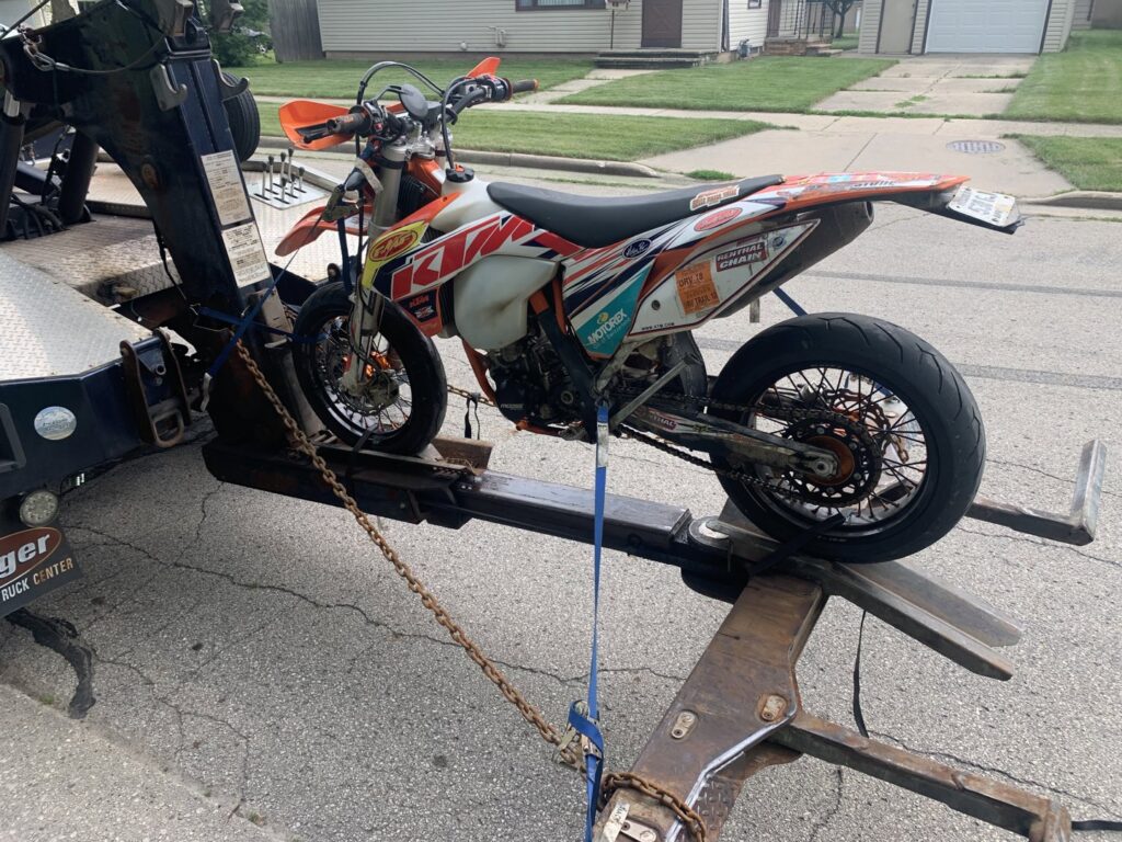 A&W Towing and Repair wheel-lift tow truck towing a dirt bike in Appleton, WI.