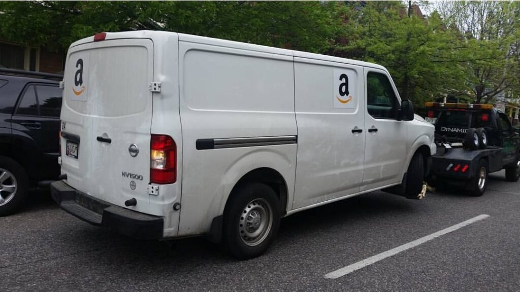 A white Amazon delivery van being towed by Whitelock Towing in Baltimore, MD.