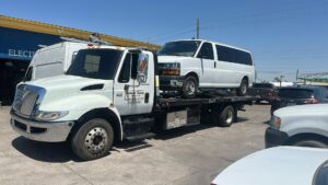 A white Ford F-250 pickup truck being transported on a flatbed tow truck by Crisanto Towing in Phoenix, AZ.