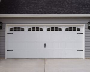 A classic white garage door with decorative windows and black hardware installed by The Door Man - Garage Doors & Openers in Reno, NV