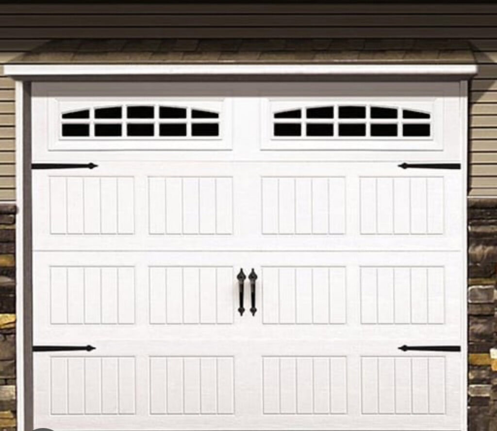 A white garage door with decorative hardware and windows installed by Total Garage Solutions in Kalispell, MT.