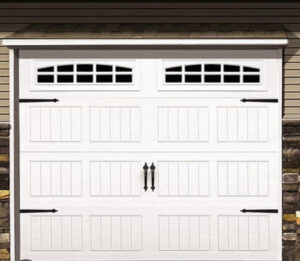 A white garage door with decorative hardware and windows installed by Total Garage Solutions in Kalispell, MT.