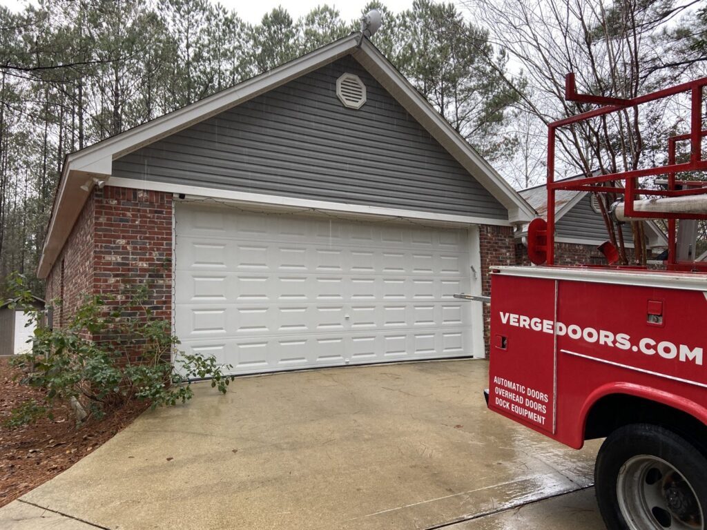 A white garage door installation or repair job with a Verge truck nearby by Jonathan at Verge in Hattiesburg, MS.