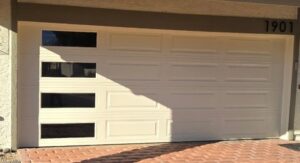 A white garage door with horizontal windows on the left side installed by Giddy Up Garage Doors & Iron in Las Vegas, NV.
