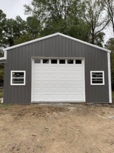 A white garage door with top windows installed on a gray metal building by LaFrancis Overhead Door LLC in Little Rock, AR