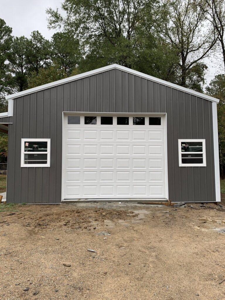 A white garage door with top windows installed on a gray metal building by LaFrancis Overhead Door LLC in Little Rock, AR