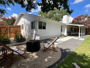 The backyard view of a home with new white horizontal siding, a project by Ideal Siding Austin in Austin, TX.
