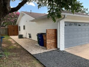 A house with white horizontal siding and a modern gray garage door, a completed project by Ideal Siding Austin in Austin, TX.