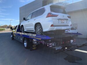A white Lexus SUV is secured on a flatbed tow truck by S&F Towing in Oakland, CA.