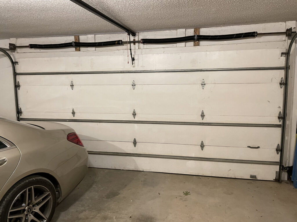 A white panel garage door with windows on a new construction home by Fayetteville Garage Door Co. in Fayetteville, AR