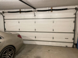 A white panel garage door with windows on a new construction home by Fayetteville Garage Door Co. in Fayetteville, AR