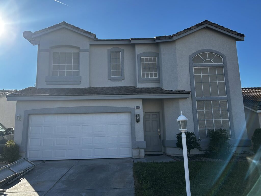 A white panel garage door installed on a residential home by K & B Door Co. in Las Vegas, NV