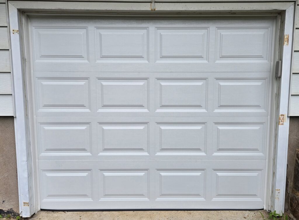 A white panel garage door, showcasing repair or new installation work by The Garage Door Guys, LLC in New Haven, CT.