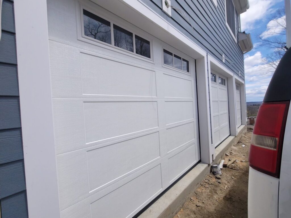 Close-up of a newly installed white panel garage door with windows by RidgeLine Overhead Garage Door of CT in Danbury, CT
