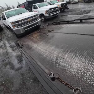 A white pickup truck being winched onto a flatbed tow truck by Columbus Towing in Columbus, GA.