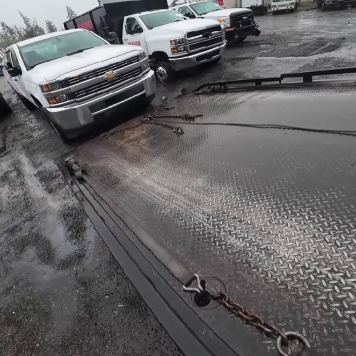 A white pickup truck being winched onto a flatbed tow truck by Columbus Towing in Columbus, GA.