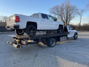 A white pickup truck loaded onto a flatbed tow truck, providing towing services by Swift Response Road Services, LLC in Memphis, TN.