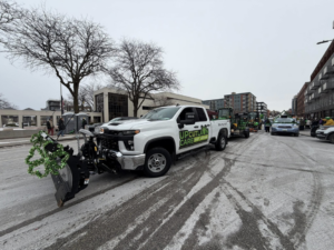 A white pickup truck with a snow plow attached, ready for snow removal services by Up Cut Lawn Care in Ankeny, IA.