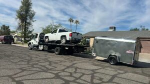 A white pickup truck and an enclosed trailer being transported by Crisanto Towing in Phoenix, AZ.