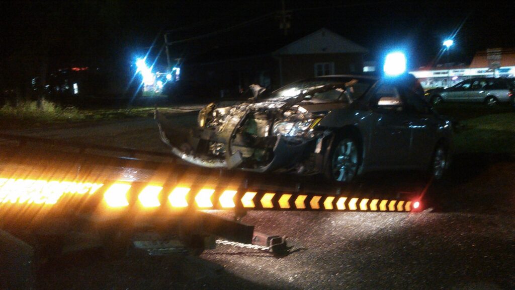 A white Porsche Panamera being transported on a flatbed tow truck by Baltimore Towing Service LLC in Owings Mills, MD.