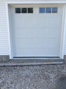 A newly installed white sectional garage door with top windows by Douglas Garage Door Center in East Hartford, CT.