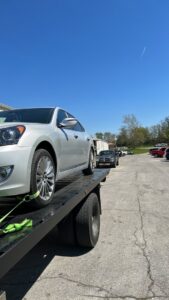 A white sedan loaded onto a flatbed tow truck for transport by Tow Truck Company in Johnson City, TN.