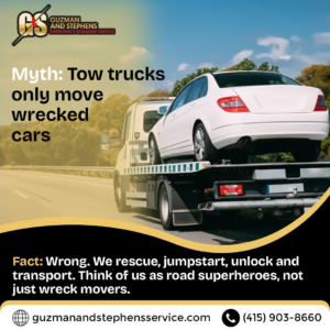 A white sedan being transported on a flatbed tow truck by Guzman Towing Services in Oakland, CA.