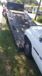 A white SUV being loaded onto a red flatbed tow truck by Spokane Towing Services in Spokane, WA.