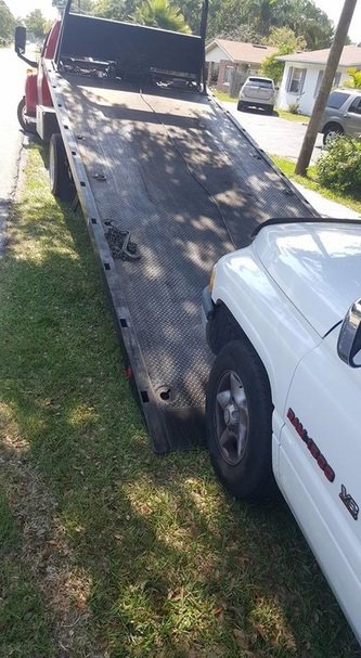 A white SUV being loaded onto a red flatbed tow truck by Spokane Towing Services in Spokane, WA.