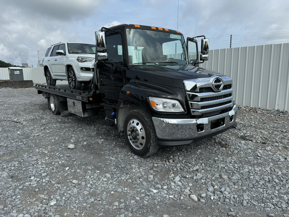 A white SUV loaded onto a flatbed tow truck from Southeastern Towing and Transport in Savannah, GA.