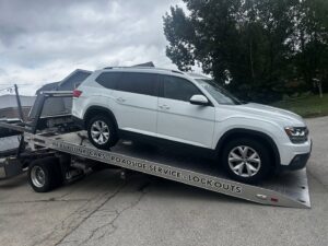A white SUV being loaded onto a flatbed tow truck by Towing Recovery Rebuilding Assistance Services in Naperville, IL