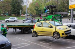 A white SUV being positioned for loading onto a flatbed tow truck by Spokane Towing Services in Spokane, WA.