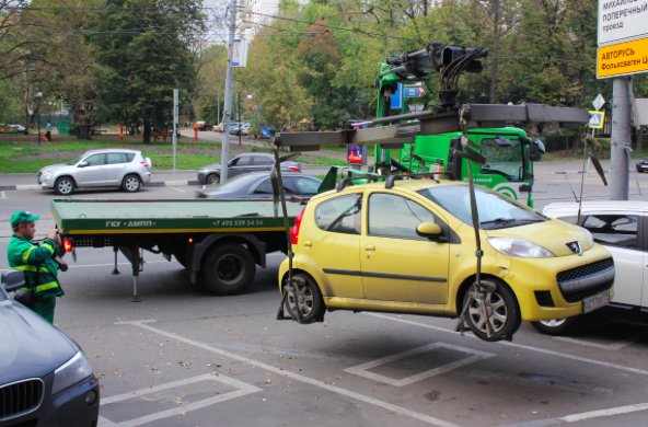 A white SUV being positioned for loading onto a flatbed tow truck by Spokane Towing Services in Spokane, WA.