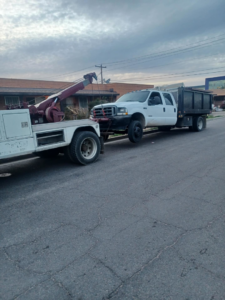 A white tow truck actively towing a white dump truck by P&A towing & transport Llc in Phoenix, AZ
