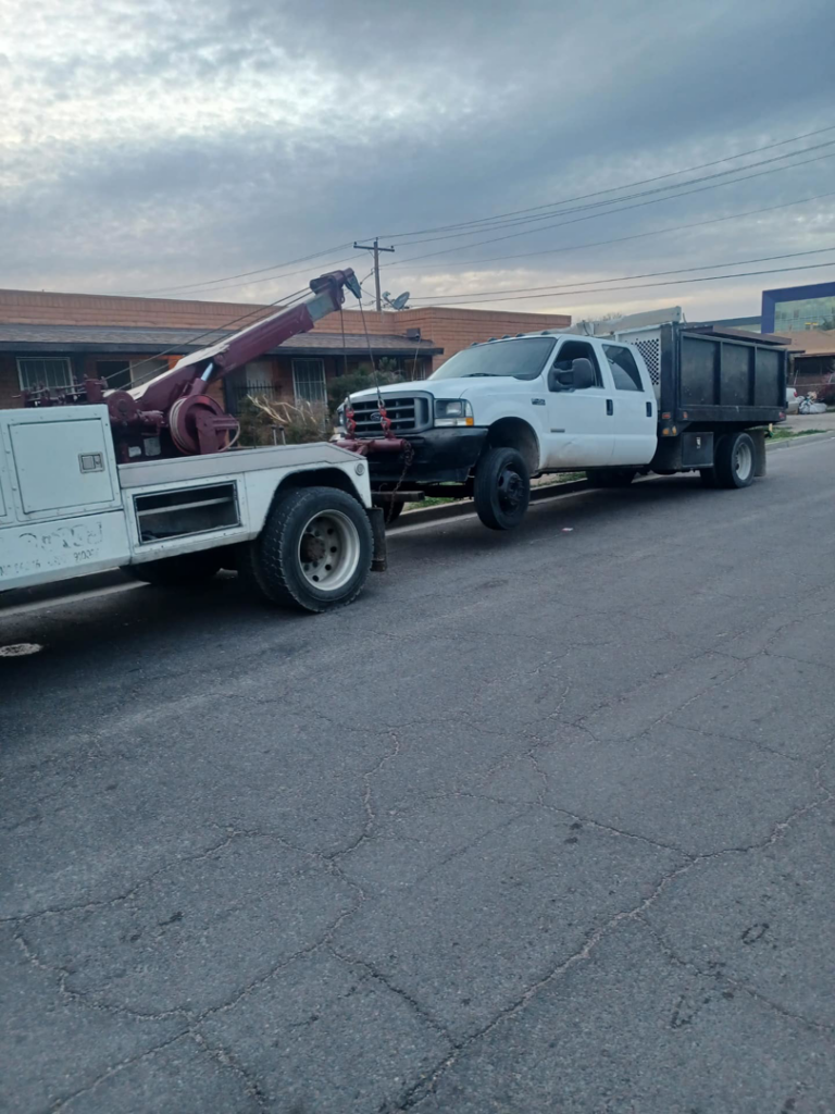 A white tow truck actively towing a white dump truck by P&A towing & transport Llc in Phoenix, AZ