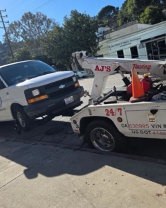 A white van being towed by a wheel-lift tow truck from Towing Near Me 247 LLC Dallas in Dallas, TX.