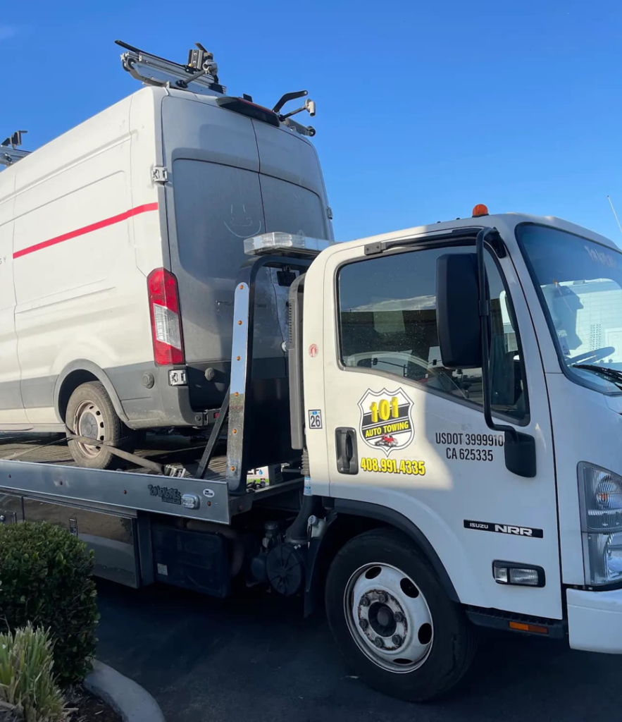 A white commercial van being towed on a flatbed truck by 101 auto towing inc in San Jose, CA.
